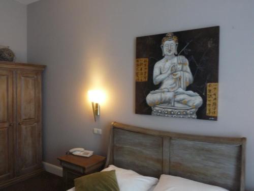 ein Schlafzimmer mit einem Bett mit einer Statue an der Wand in der Unterkunft Hotel Commodore in Hamburg