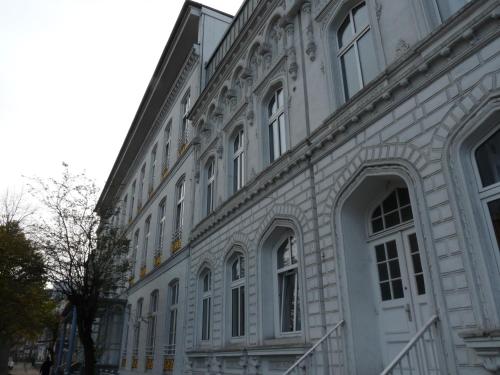 a white building with many windows on a street at Hotel Commodore in Hamburg