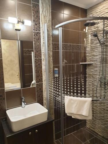a bathroom with a sink and a shower at Kastélykert Fogadó in Szeged