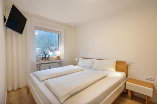 a white bed in a room with a window at Oberstdorfer Bergwelt 246 in Oberstdorf