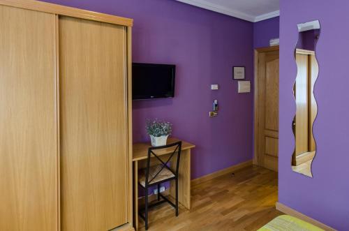 a room with purple walls and a wooden door at Las Abadías in Mérida