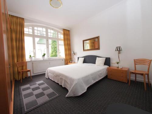 a bedroom with a large white bed and a window at Villa Sirene Whg 12 Meerblick - 5 Sterne in Binz