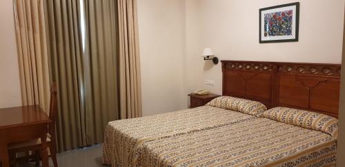 
a bedroom with a bed and a dresser at Apartamentos Nerja Bahia in Nerja
