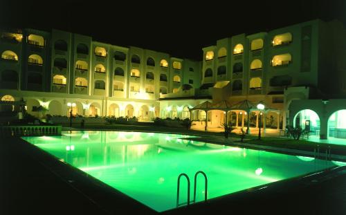 a large pool in front of a building at night at Hôtel Green Golf Hammamet in Hammamet
