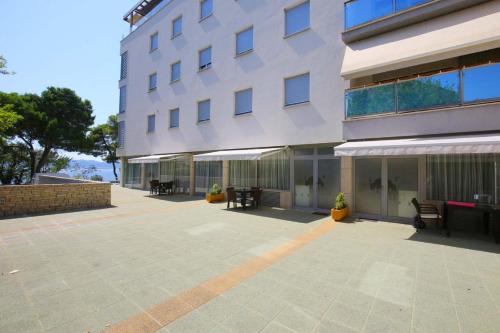 a building with benches and tables in front of it at Apartmani Luce in Zadar