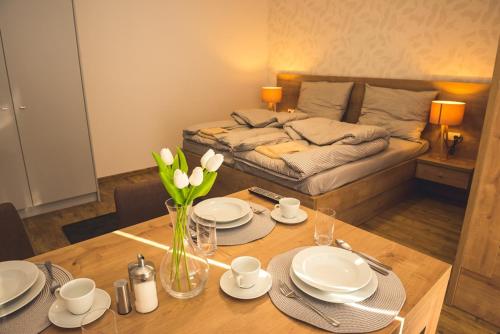 a living room with a table and a bed at Vila Anna - Ubytovanie Bešeňová in Bešeňová