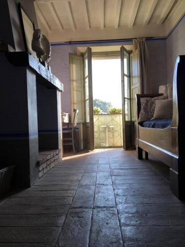 a room with a fireplace and a door to a balcony at B&B Locanda Toscanini in Cetona