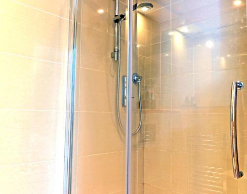 uma cabina de duche com uma porta de vidro na casa de banho em The Playwright em Eastbourne