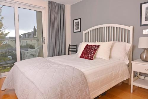 sypialnia z łóżkiem i dużym oknem w obiekcie The Playwright w mieście Eastbourne
