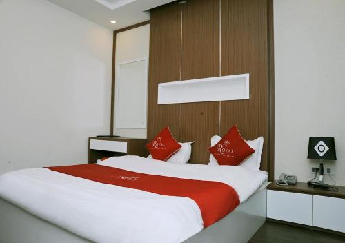 a bedroom with a large bed with red pillows at The Royal Hotel Near West Lake in Hanoi