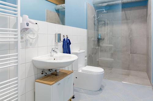 a bathroom with a sink and a toilet and a shower at Argenta Living 131 in Künzell