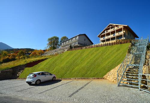 a small car parked in a parking lot next to a building at Dom Górski in Karpacz