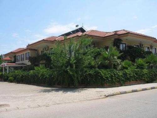 a large house with a lot of bushes and trees at MG Moms Hotel in Kemer