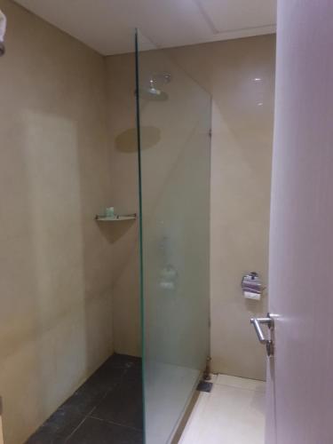 a shower with a glass door in a bathroom at Hotel DRAGON INN Kemayoran in Jakarta