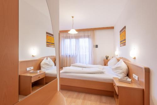 Habitación de hotel con cama y espejo en Seaberhof, en Caldaro