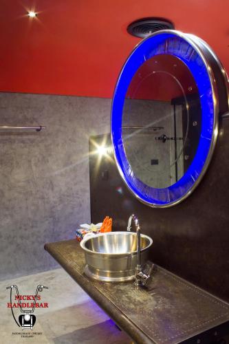a bathroom with a sink and a blue mirror at Nicky's Handlebar in Patong Beach