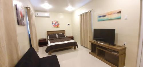 Un dormitorio con una cama y un televisor de pantalla plana. en Beautiful Apartment minutes from the Beach, en Jan Thiel