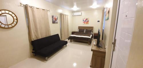 Un dormitorio con una cama, un sofá y un espejo. en Beautiful Apartment minutes from the Beach, en Jan Thiel