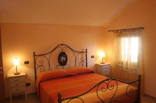una camera con un letto con due comodini e due lampade di Agriturismo Isorella a Cherasco