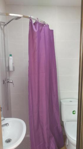a purple shower curtain in a bathroom with a sink at GOLDEN TOWER pensión Auto Check-in in Gandía