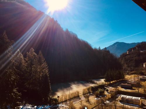 a view of a mountain with the sun shining on it at Ostello Brembo in Camerata Cornello