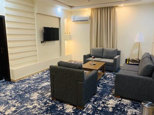 a living room with two couches and a tv at Lova Suites in Yanbu