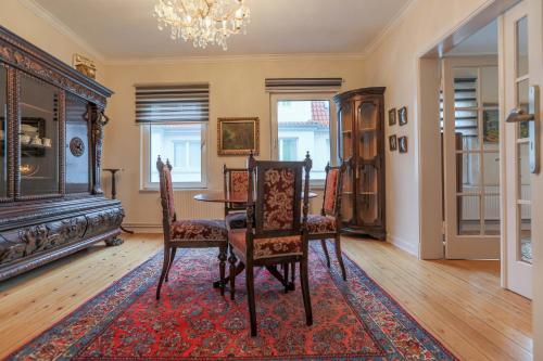 a dining room with a table and chairs and a chandelier at Ferienwohnung Coco in Lübeck