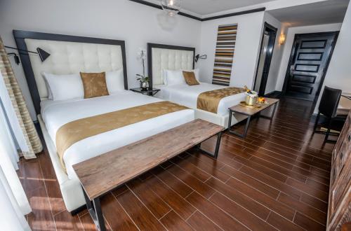 a bedroom with two beds and a wooden floor at Hotel Croydon in Miami Beach