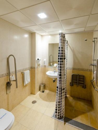 a bathroom with a sink and a shower and a toilet at Las Abadías in Mérida
