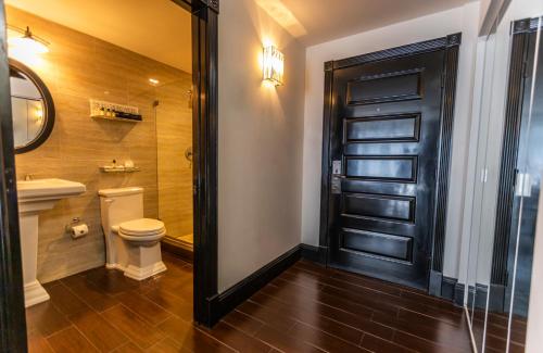 a bathroom with a toilet and a black door at Hotel Croydon in Miami Beach