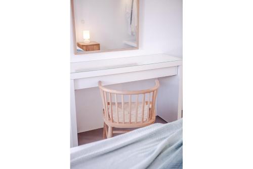a bedroom with a mirror and a chair next to a bed at Agnandi Cielo in Tourlos