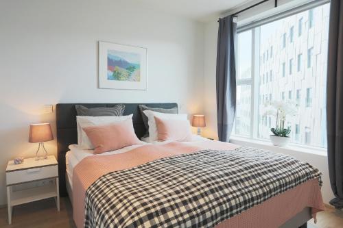 Un dormitorio con una cama grande con ventana. en Salka suites, en Reikiavik