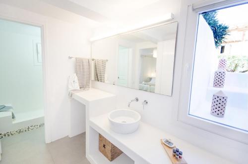 a white bathroom with a sink and a mirror at Agnandi Cielo in Tourlos