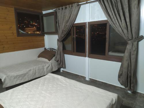 a bedroom with two beds and a window at Success Hostel in Nablus