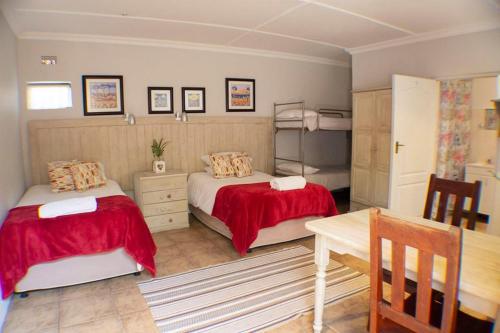 a bedroom with two beds and a table in it at A Place of Grace in Durban