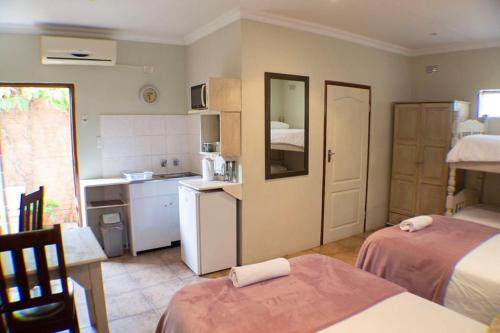 Habitación con 2 camas y cocina con cocina. en A Place of Grace en Durban