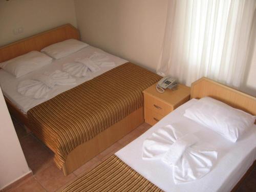 a small bedroom with a bed and a telephone at MG Moms Hotel in Kemer