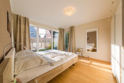 Tempat tidur dalam kamar di PREMIUM-LODGE im DER SÜDSCHWEDE ... Dein Gästehaus mitten in Zingst