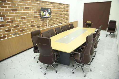 a conference room with a wooden table and chairs at SAJ Farm Inn in Ibrā