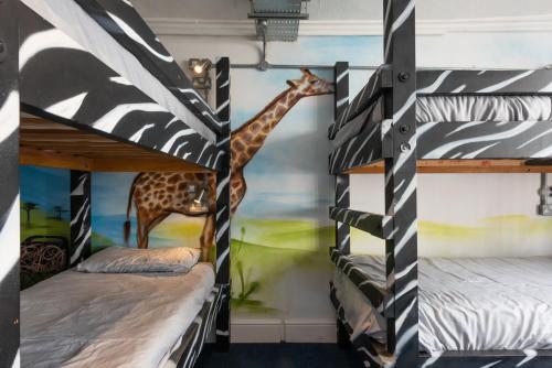 two bunk beds in a room with a giraffe mural at The Full Moon Backpackers in Bristol