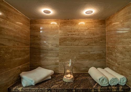 a bathroom with two towels and a glass vase at Pension Jana - Wellness in Jilemnice