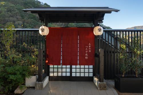 
a walkway leading to a building with a bench at Onsen Guest House Tsutaya in Hakone

