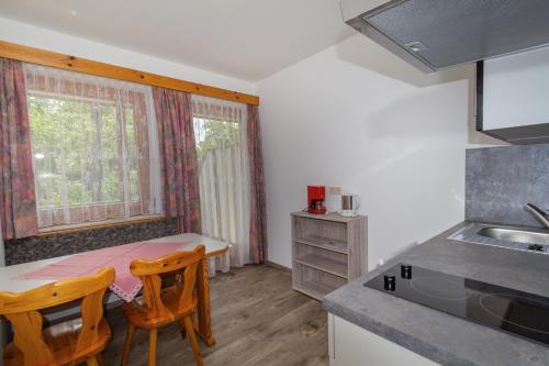 a kitchen with a table and two chairs and a sink at Ferienwohnungen Petschnig 2 in Drobollach am Faakersee