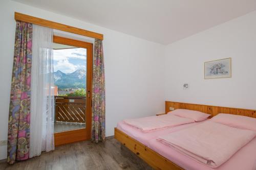 a bedroom with a bed and a large window at Ferienwohnungen Petschnig 2 in Drobollach am Faakersee