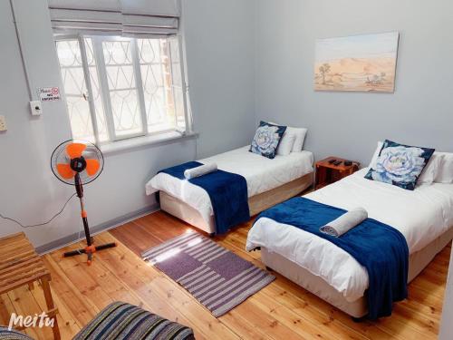 a room with two beds and a window at Keetmanshoop Self-catering in Keetmanshoop