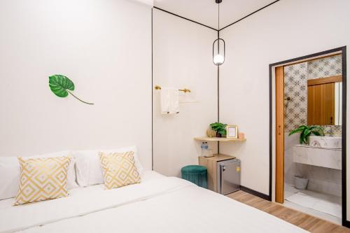 a bedroom with a white bed and a bathroom at Isara Boutique Hotel and Cafe in Phuket Town