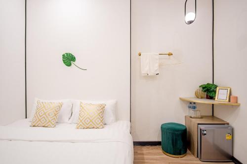 a white bedroom with a bed and a table at Isara Boutique Hotel and Cafe in Phuket Town
