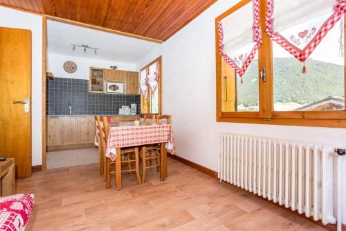 une cuisine et une salle à manger avec une table et une fenêtre dans l'établissement Piste B, à Morzine