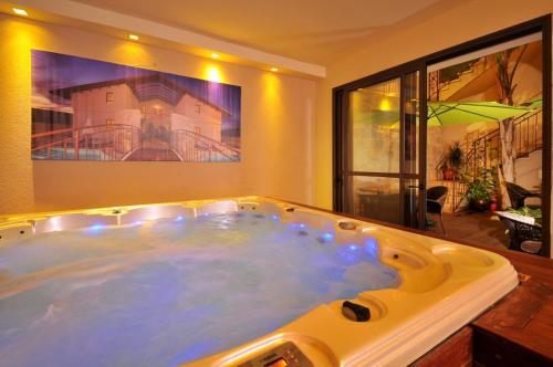 a large jacuzzi tub in a living room at Elisheva Boutique Suite in ‘Amqa