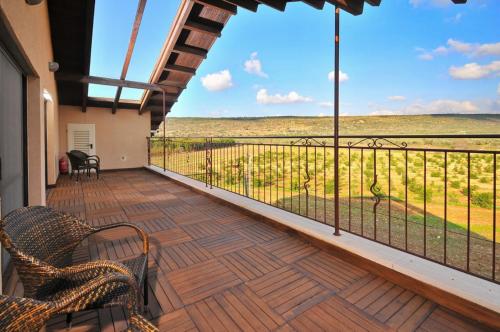 a balcony with chairs and a view of a field at Elisheva Boutique Suite in ‘Amqa